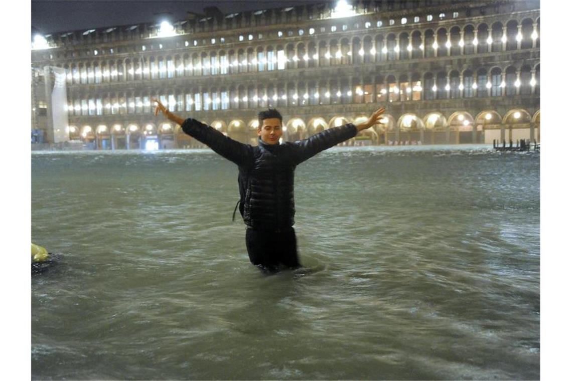 Ein Mann steht im Hochwasser auf dem überschwemmten Markusplatz. Foto: Andrea Merola/ANSA/AP/dpa