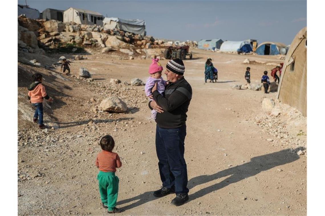 Schlechte Ernte droht Hungerkrise in Syrien zu verschärfen Ein Mann steht mit seinen Kindern in einem Flüchtlingslager in der Provinz Idlib. Foto: Anas Alkahrboutli/dpa/dpa