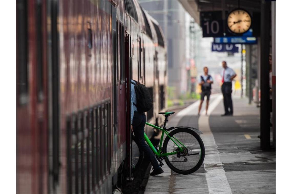 Ein Mann steigt mit seinem Fahrrad in einen Zug. Foto: Andreas Arnold