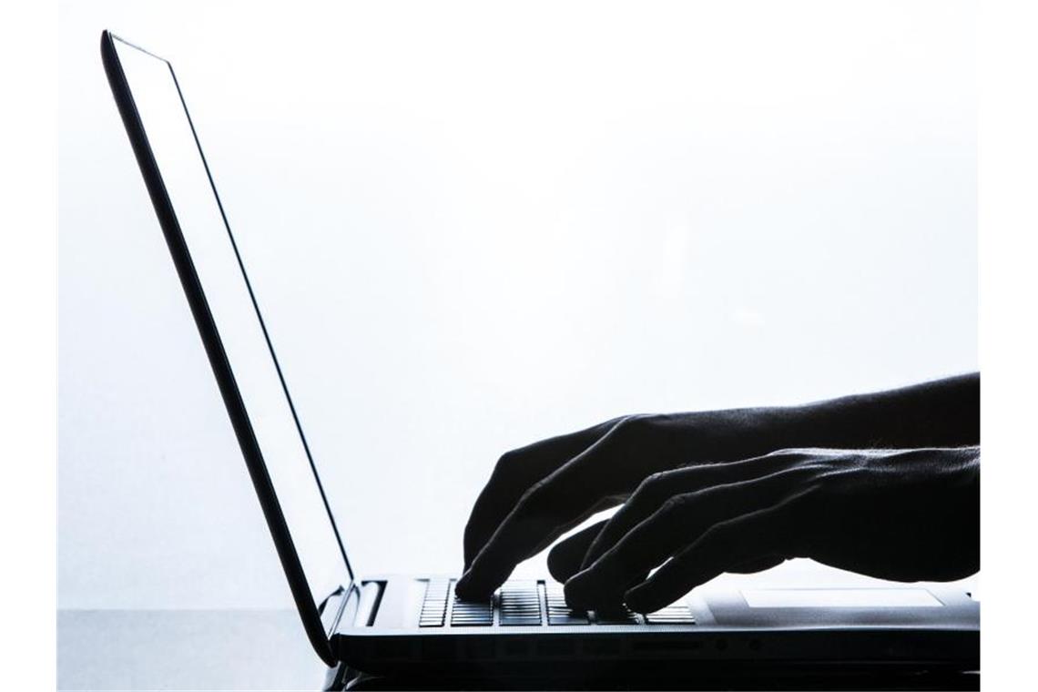 Ein Mann tippt auf einer Tastatur eines Laptops. Foto: Silas Stein/Archivbild