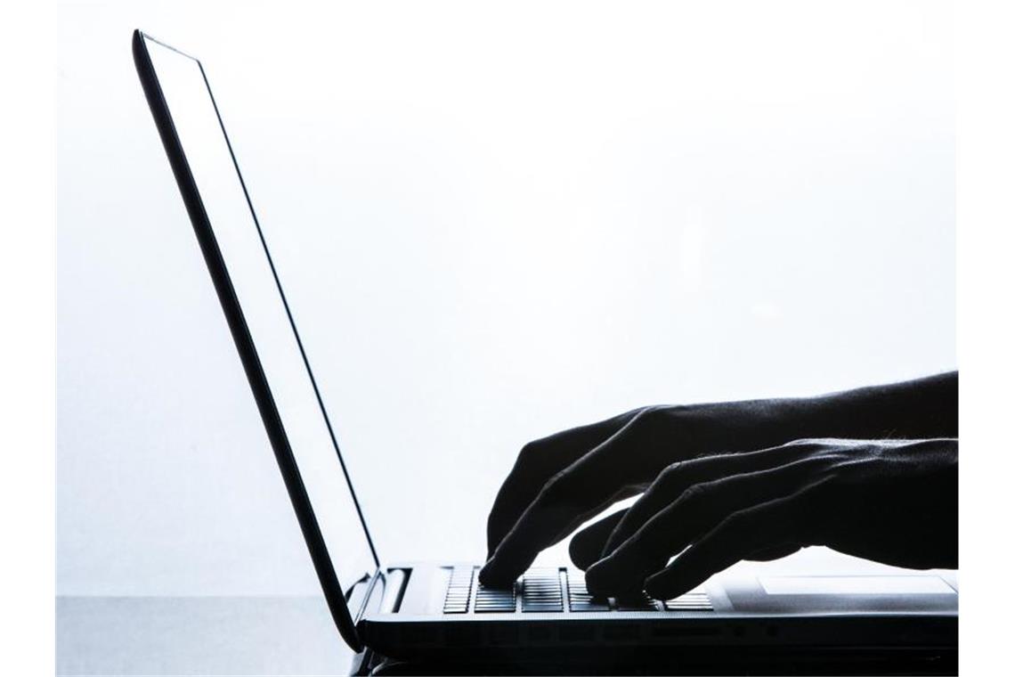 Ein Mann tippt auf einer Tastatur eines Laptops. Foto: Silas Stein/Archivbild