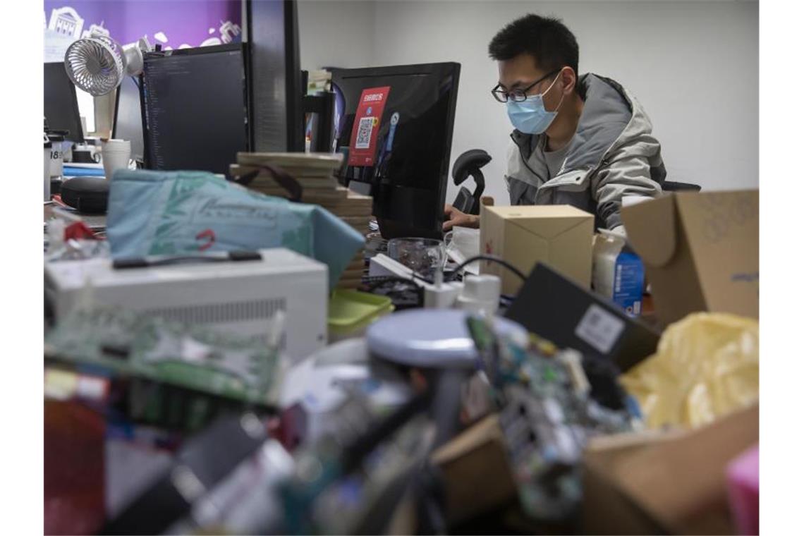China meldet erstmals keine Corona-Neuinfektionen Ein Mann trägt bei der Arbeit in einem Technologieunternehmen in Peking einen Mundschutz. Foto: Mark Schiefelbein/AP/dpa