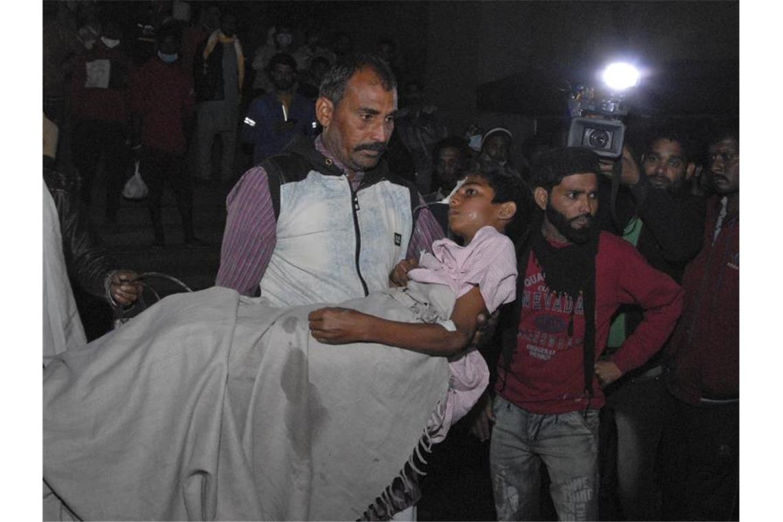 Vier Neugeborene sterben bei Feuer in Krankenhaus Ein Mann trägt ein Kind aus dem Kamla Nehru Children's Hospital im indischen Bhopal. Foto: Uncredited/AP/dpa