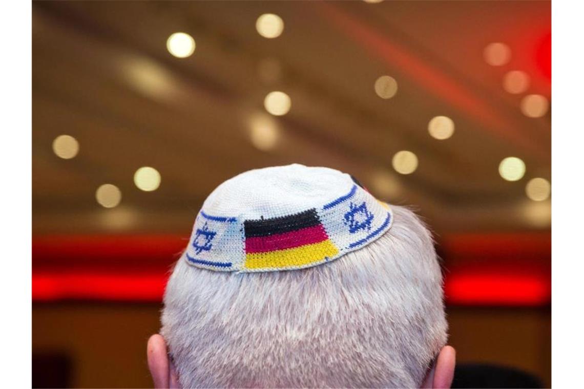 Ein Mann trägt eine Kippa mit eingearbeiteten israelischen und deutschen Fahnen. Foto: Frank Rumpenhorst