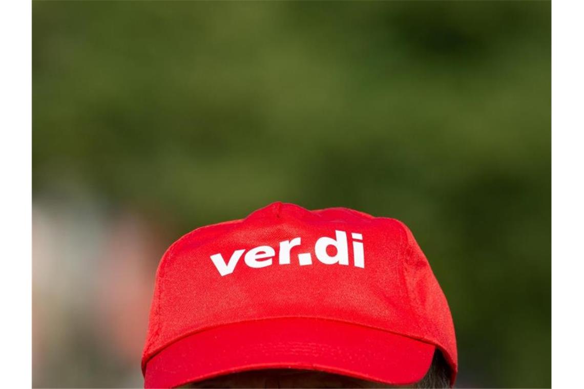 Ein Mann trägt eine Mütze mit dem Verdi Logo. Foto: Christophe Gateau/dpa/Symbolbild