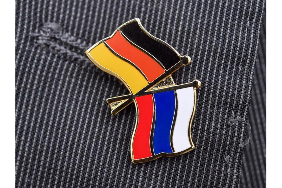 Spitzenverbände der Wirtschaft starten Hilfsinitiative Ein Mann trägt einen Anstecker mit einer kleinen deutschen und einer kleinen russischen Flagge an seinem Sakko. Foto: Patrick Pleul/ZB/dpa
