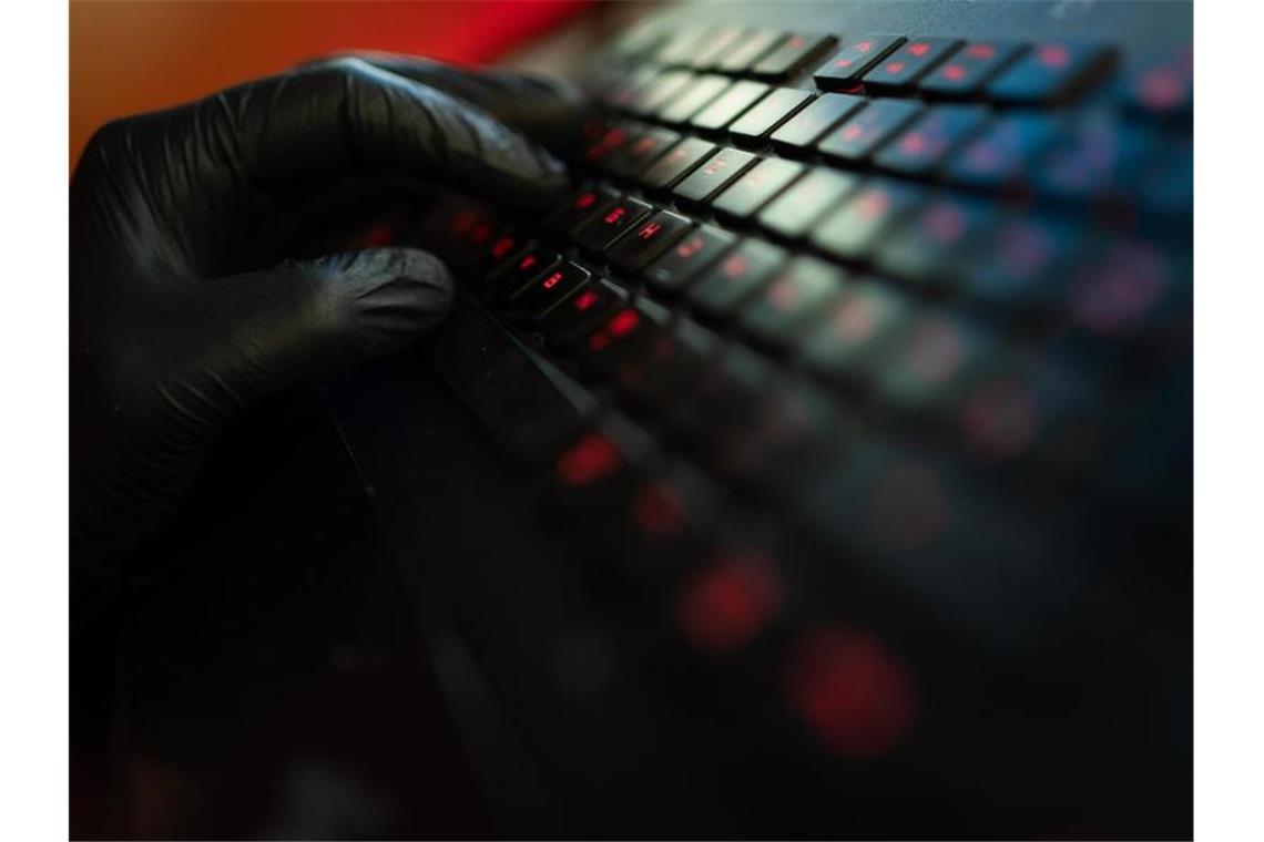 Ein Mann trägt Handschuhe und tippt auf der Tastatur eines Computers. Foto: Nicolas Armer/dpa/Archivbild