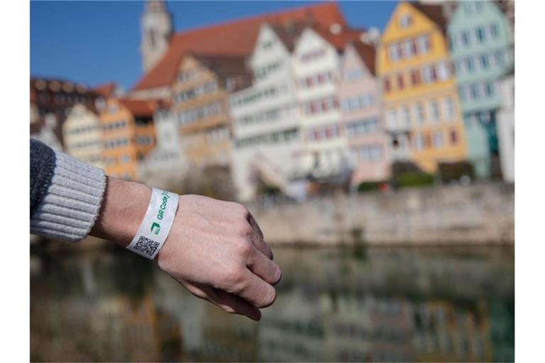 Ein Mann trägt in Tübingen ein Tagesticket-Armband. Foto: Christoph Schmidt/dpa/Archivbild