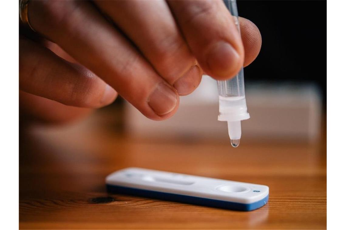 Rotes Kreuz stößt wegen Selbsttests in Klassen auf Kritik Ein Mann träufelt eine Lösung auf eine Testkassette, die von Covid-19 verursachte Antigene nachweisen kann. Foto: Zacharie Scheurer/dpa/Symbolbild
