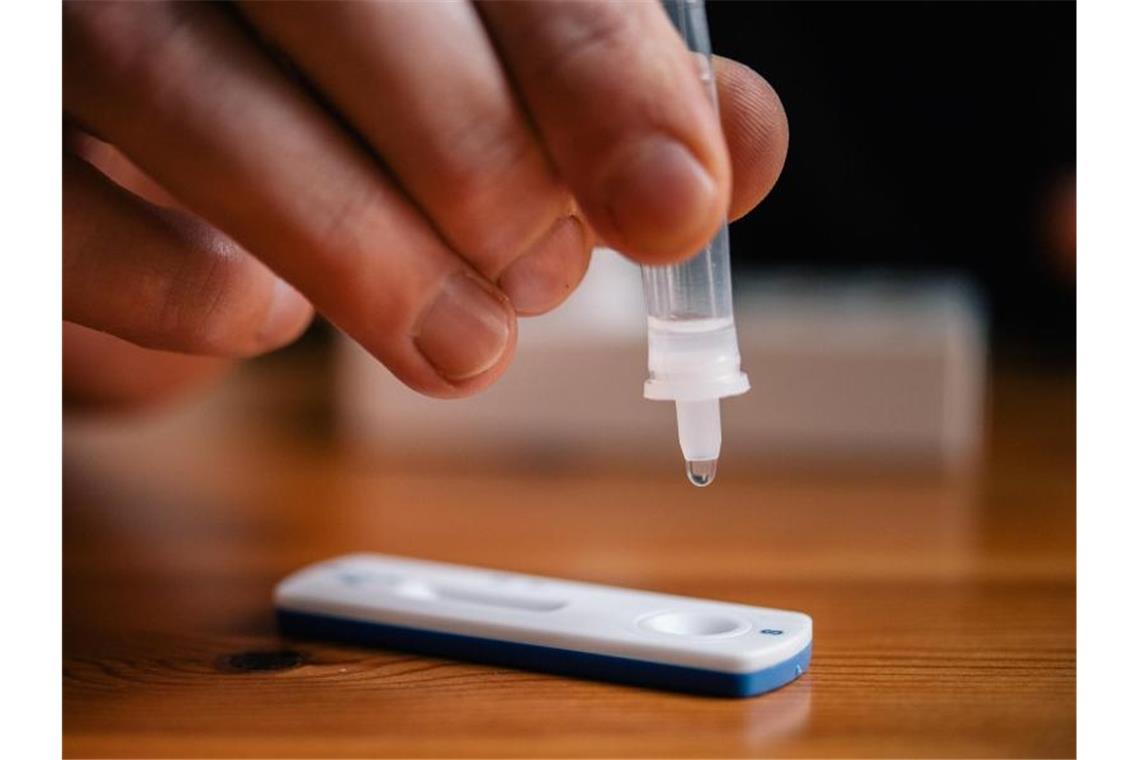 Land will Qualität der Testanbieter kontrollieren lassen Ein Mann träufelt eine Lösung auf eine Testkassette für einen Schnelltest. Foto: Zacharie Scheurer/dpa/Symbolbild
