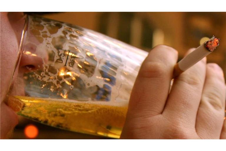Ein Mann trinkt in einer Gaststätte ein Bier und raucht dazu eine Zigarette. Damit Menschen wie ihm diese ungesunde Lebensweise vergeht, müssen die Steuern auf Alkohol und Tabak deutlich angehoben werden, fordert der Präventionsökonom Tobias Effertz.