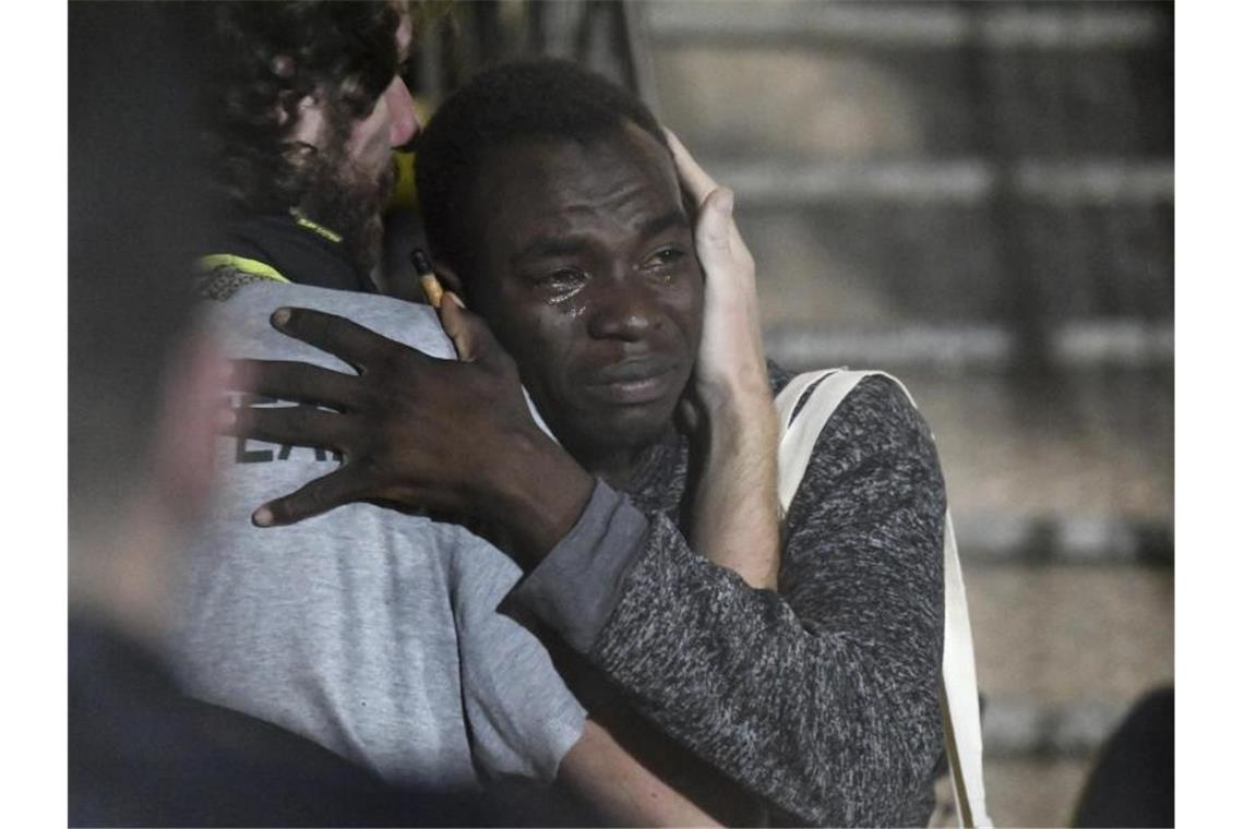 Migranten gehen in Italien von Bord der „Open Arms“ Ein Mann umarmt weinend ein Besatzungsmitglied, nachdem auf Lampedusa angekommen ist. Foto: Salvatore Cavalli/AP