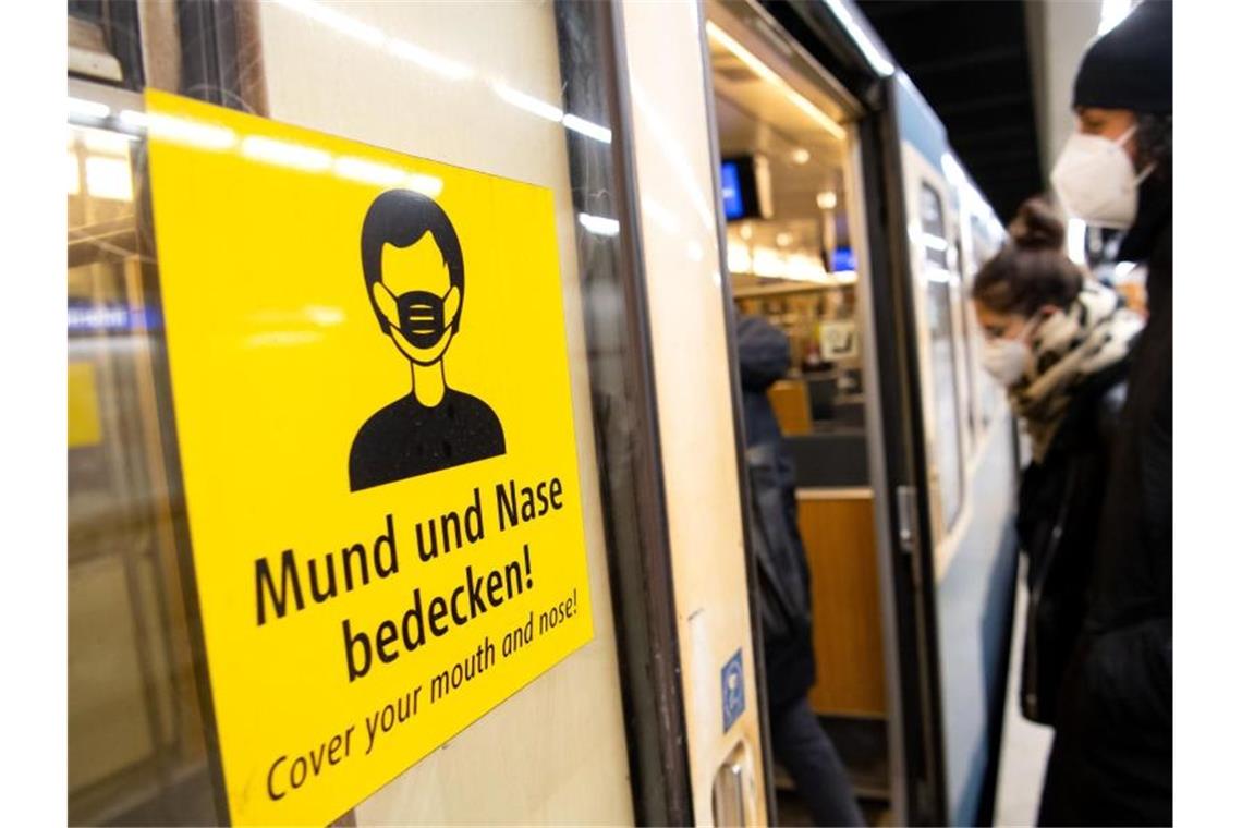 Corona-Einschränkungen gelten vorerst weiter - mit Ausnahmen Ein Mann und eine Frau mit FFP2-Masken steigen in einer Münchner U-Bahnstation in die Bahn. Foto: Sven Hoppe/dpa