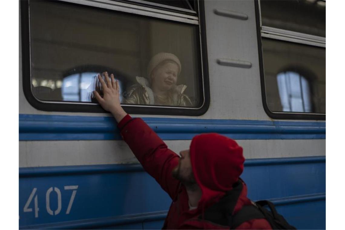 Ein Mann verabschiedet ein weinendes Mädchen in einem Zug in Lwiw. Foto: Bernat Armangue/AP/dpa