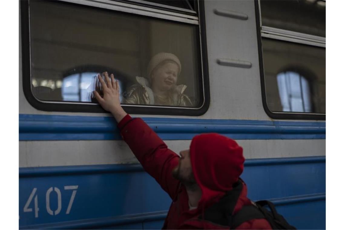 Krieg gegen die Ukraine: So ist die Lage Ein Mann verabschiedet ein weinendes Mädchen in einem Zug in Lwiw. Foto: Bernat Armangue/AP/dpa