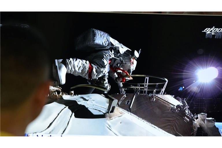 Ein Mann verfolgt vor dem Fernseher die Live-Übertragung eines Außeneinsatzes an der Raumstation "Tiangong" (Archivbild).