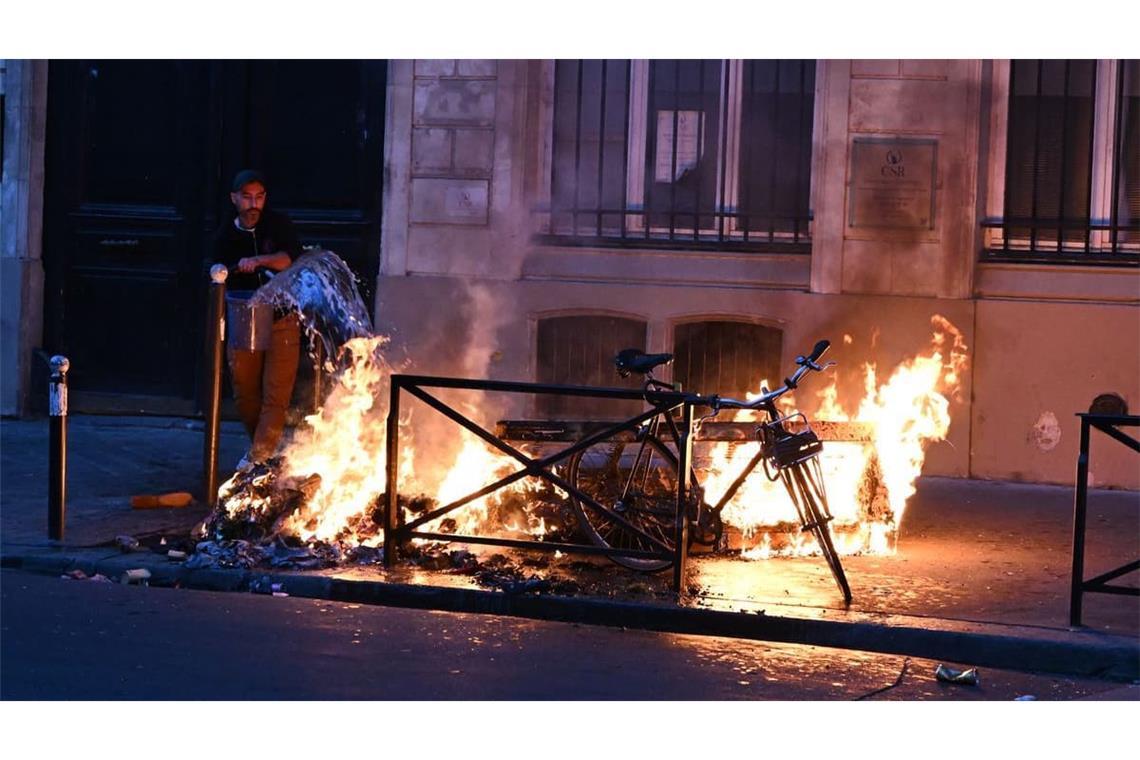 Ein Mann versucht in Paris, während der Zusammenstöße zwischen Demonstranten und Polizeibeamten ein Feuer zu löschen. 