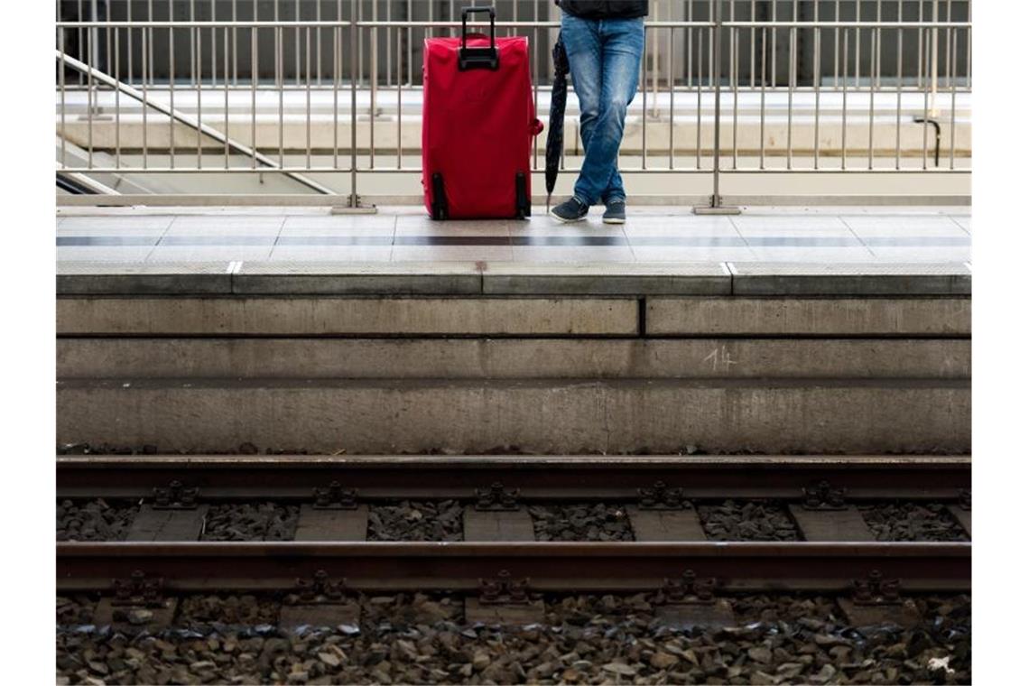 Bahnreisende in Schwaben müssen mehr Zeit einplanen Ein Mann wartet mit seinem Gepäck auf einem Bahnsteig. Foto: Arno Burgi/dpa-Zentralbild/dpa/Symbolbild