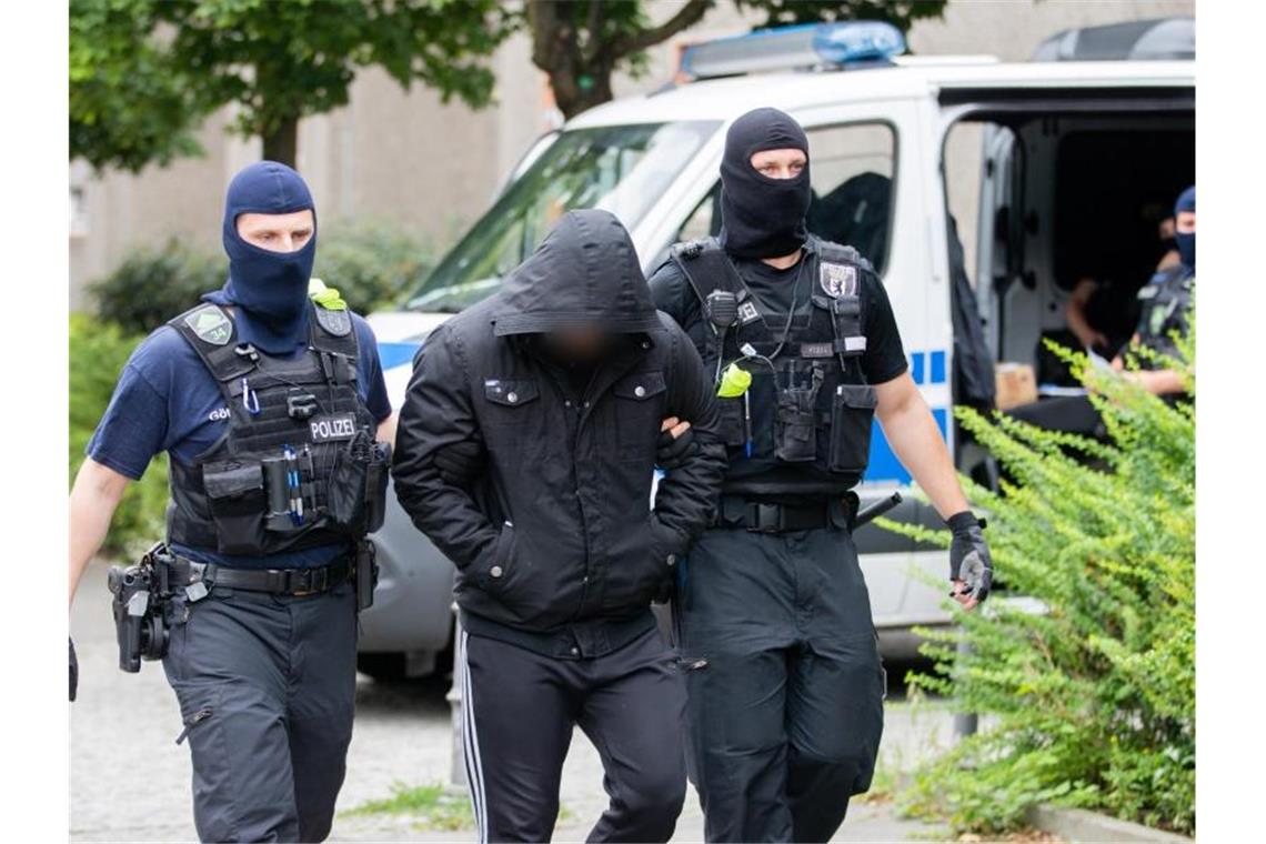 Groß angelegte Razzia gegen Islamisten-Szene in Berlin Ein Mann wird bei einem Polizeieinsatz im Rahmen einer groß angelegten Razzia gegen Tatverdächtige aus der islamistischen Szene in Berlin-Gesundbrunnen von zwei Polizisten abgeführt. Foto: Christoph Soeder/dpa