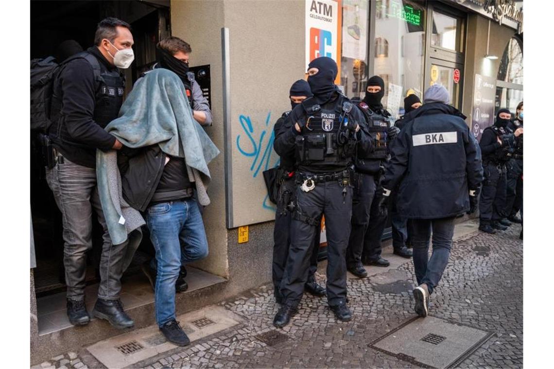 Kriminellen-Chats geknackt - Schlag gegen Clan-Kriminelle Ein Mann wird bei einer Razzia, mit einer Decke über dem Kopf, von der Polizei abgeführt. Mit einer Großrazzia ist die Polizei am Donnerstag gegen Clankriminalität in Berlin und Umgebung vorgegangen. Foto: Christophe Gateau/dpa