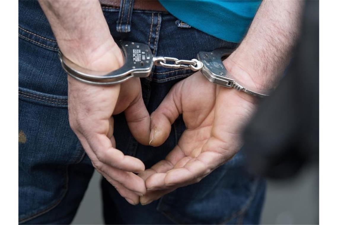 16-Jähriger nach Überfall in Gaststätte in U-Haft Ein Mann wird in Handschellen abgeführt. Foto: Boris Roessler/dpa/Archivbild