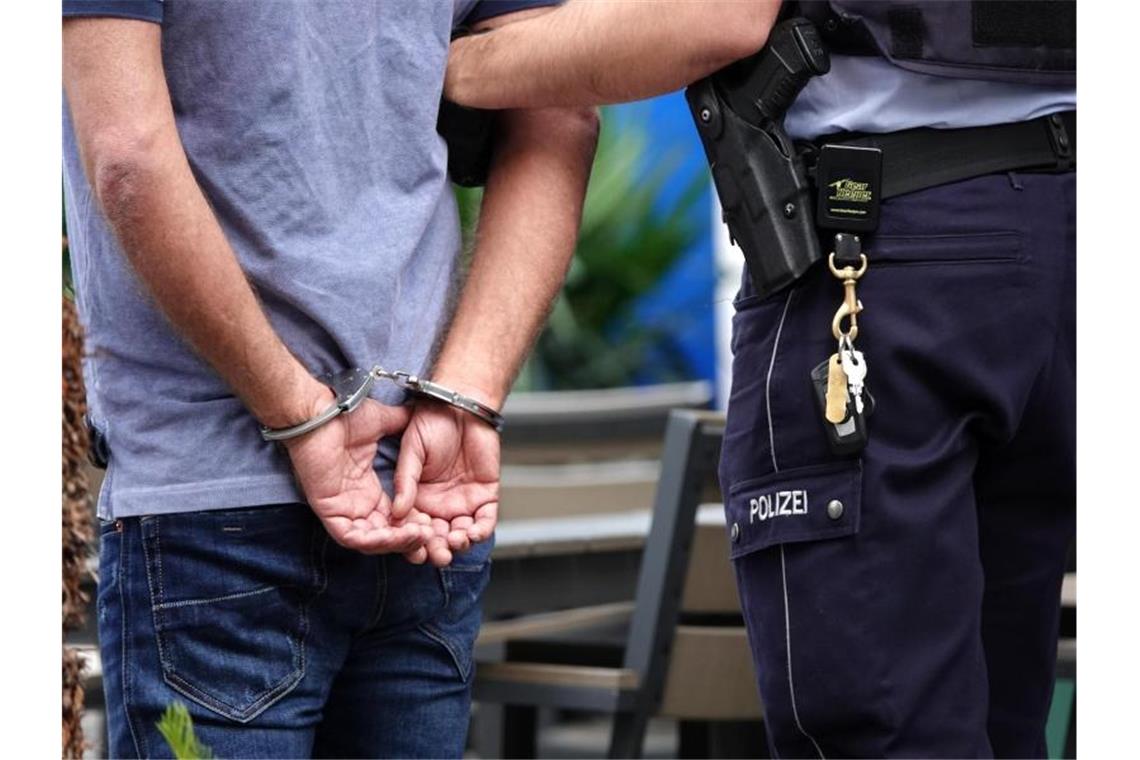 Ein Mann wird in Handschellen von der Polizei abgeführt. Foto: Johannes Neudecker/dpa/Symbolbild