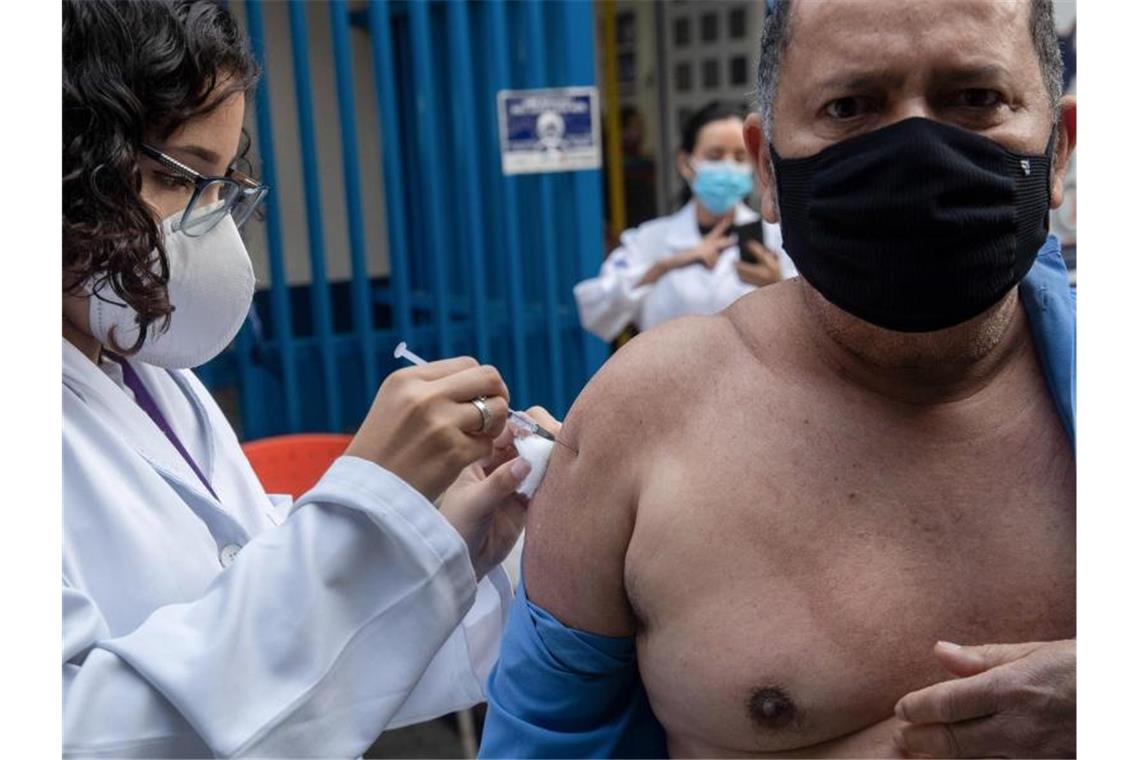 „Impf-Feinschmecker“ in Brasilien: Die Jagd nach dem Vakzin Ein Mann wird in Sao Paulo mit dem Biontech/Pfizer-Vakzin geimpft. Foto: Andre Penner/AP/dpa