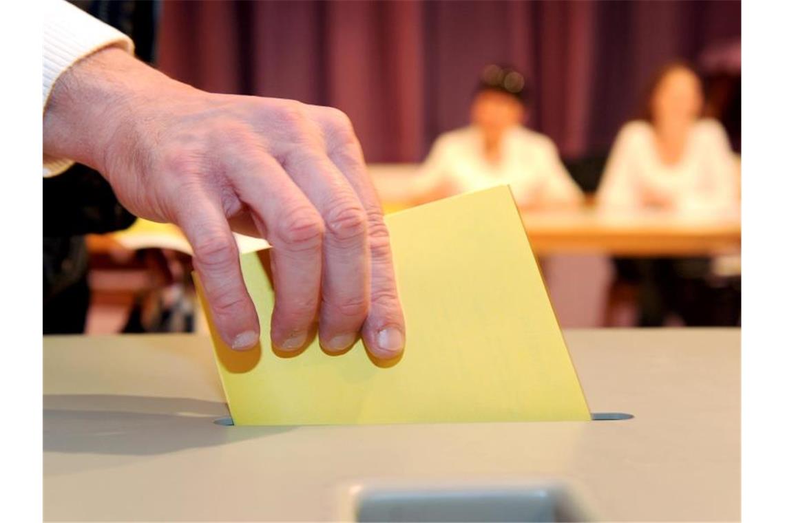 Ein Mann wirft einen Stimmzettel in eine Wahlurne. Foto: Bernd Weissbrod/dpa/Archivbild/Illustration