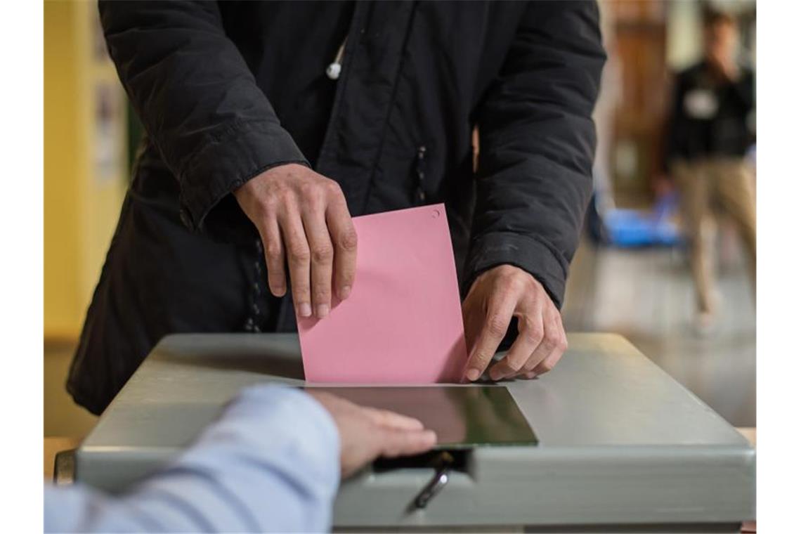 Ein Mann wirft seinen Stimmzettel in die Wahlurne. Foto: Wolfram Kastl/Archiv