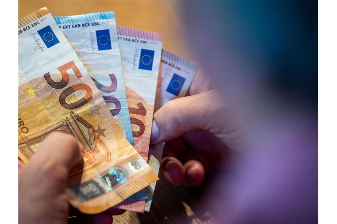 Zahlreiche Städte im Südwesten drehen an der Steuerschraube Ein Mann zählt Geld an einem Tisch. Foto: Lino Mirgeler/dpa/Symbolbild