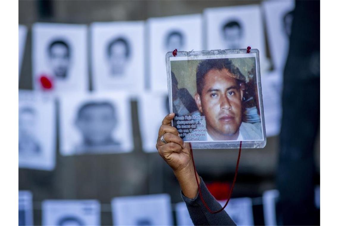 Mehr als 52.000 unidentifizierte Leichen in Mexiko Ein Mann zeigt das Bild seines 2009 verschwundenen Sohnes bei einem Protest in der mexikanischen Hauptstadt.). Foto: Jair Cabrera Torres/dpa