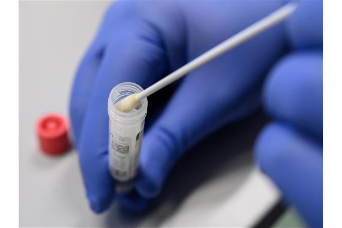 Corona-Inzidenz in Baden-Württemberg steigt weiter Ein Mann zeigt einen Abstrich für das Testverfahren auf das Virus Sars-CoV-2. Foto: Sebastian Gollnow/dpa/Symbolbild
