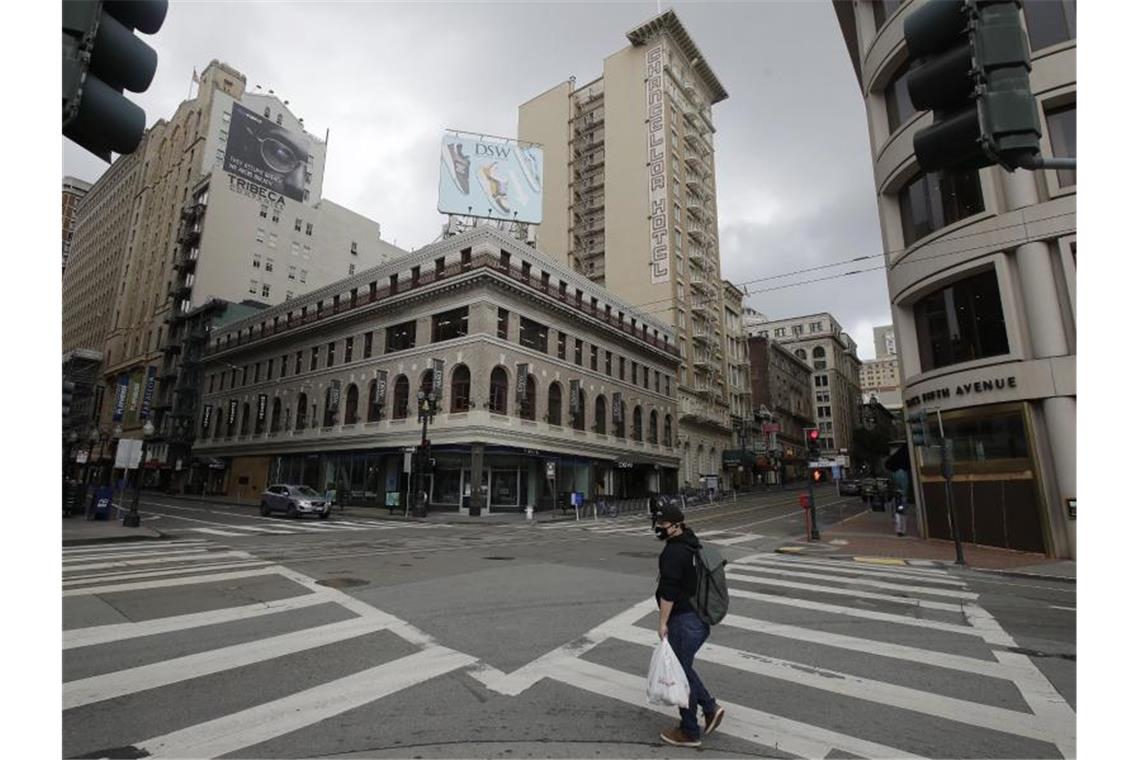 Ein Mannüberquert eine nahezu unbefahrene Kreuzung in San Francisco. Foto: Jeff Chiu/AP/dpa