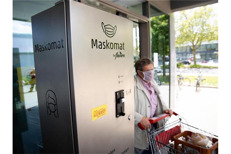 Ein „Maskomat“ des Berliner Automatenherstellers Flavura steht am Eingang eines Supermarktes. Foto: Christian Charisius/dpa