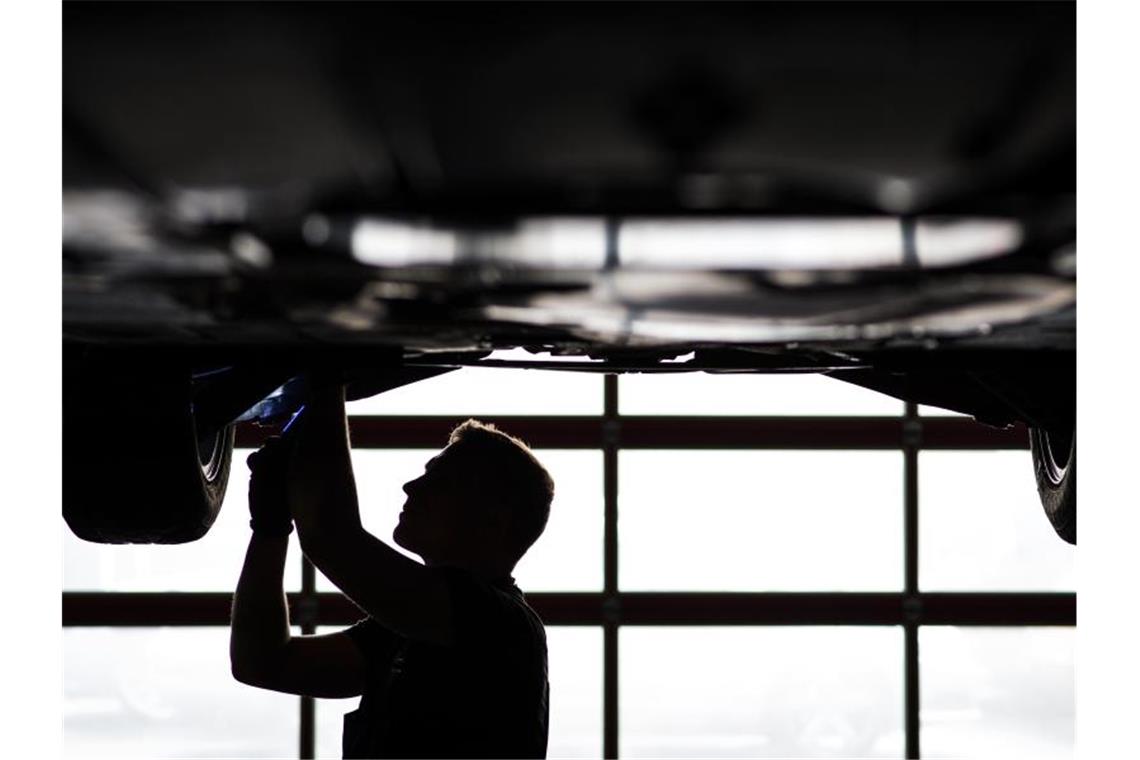 Zwang zur Datenteilung? - Autoindustrie in Sorge Ein Mechaniker arbeitet in einer KfZ-Werkstatt an der Unterseite eines Autos. Foto: David-Wolfgang Ebener/dpa