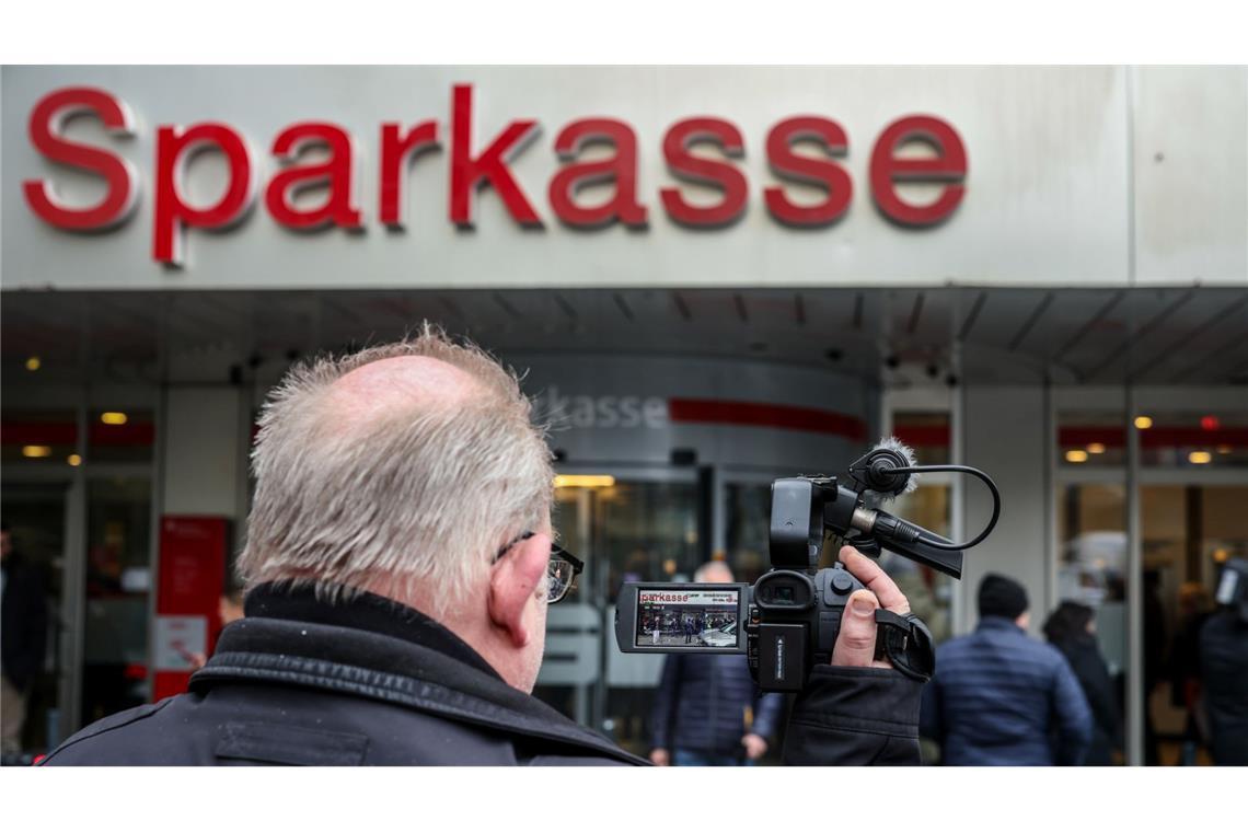 Ein Medienvertreter steht mit einer Kamera vor der Sparkassenfiliale in Buer.