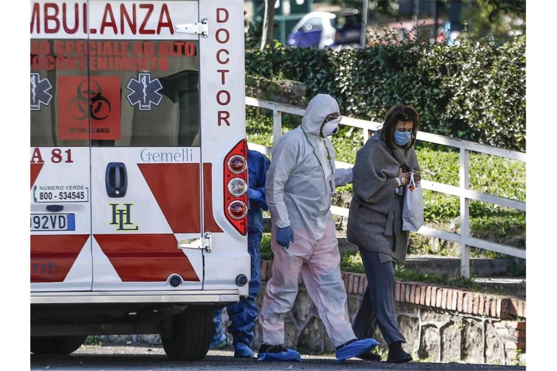 Ein medizinischer Angestellter begleitet in Rom eine Patientin ins Krankenhaus. Foto: Cecilia Fabiano/LaPresse via ZUMA Press/dpa