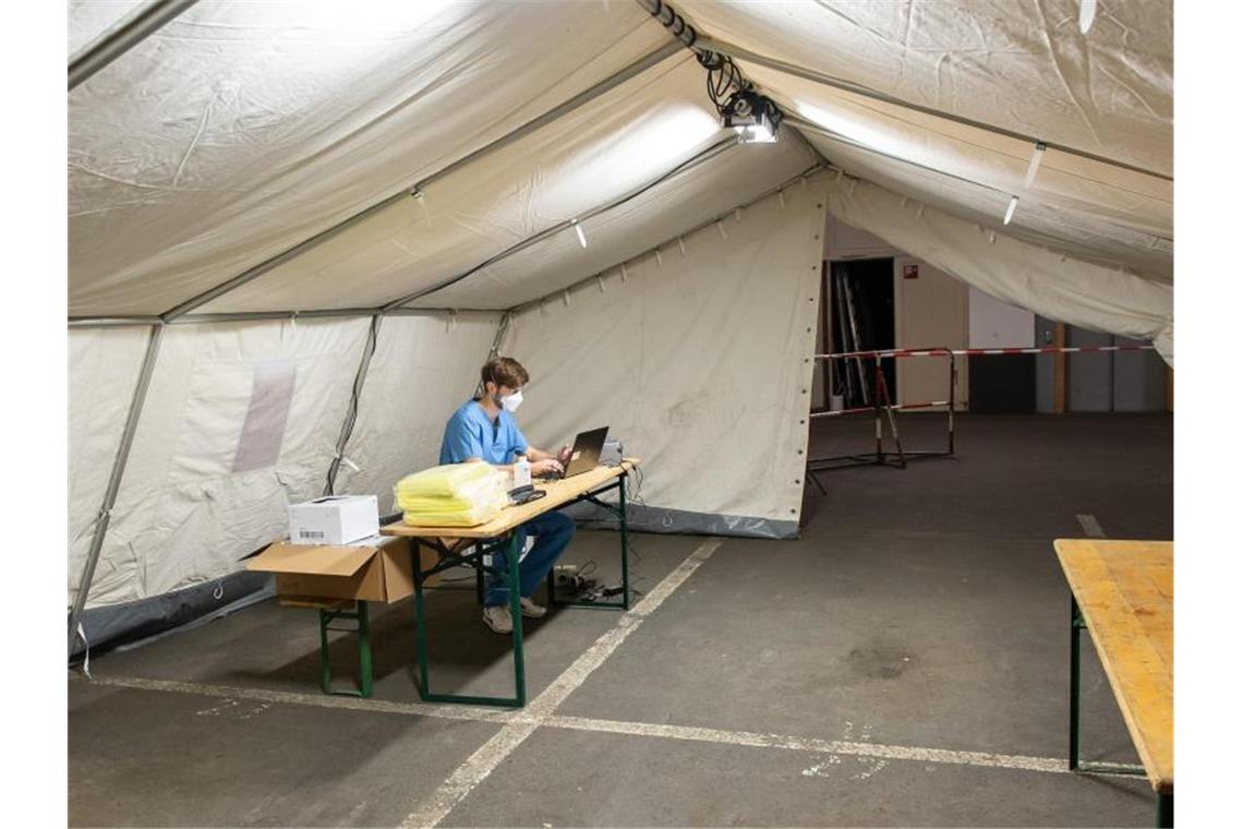 Ein medizinischer Helfer in einem aufgebauten Zelt für die Covid-19-Testung in der Tiefgarage des Iduna-Zentrum. Foto: Swen Pförtner/dpa