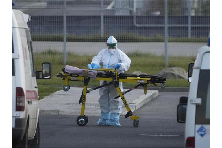 Ein medizinischer Mitarbeiter bereitet eine Trage vor einem Krankenhaus in Kommunarka vor. Foto: Alexander Zemlianichenko/AP/dpa