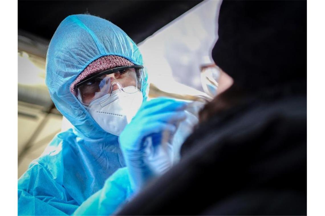 Ein medizinischer Mitarbeiter eines Corona-Testcenters führt einen Corona-Schnelltest durch. Foto: Kay Nietfeld/dpa