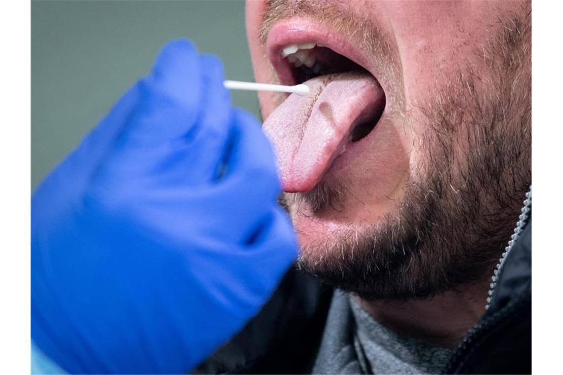 Corona-Inzidenz in Baden-Württemberg geht weiter zurück Ein medizinischer Mitarbeiter entnimmt einem Mann einen Rachenabstrich für einen Corona-Test. Foto: Matthias Balk/dpa/Symbolbild