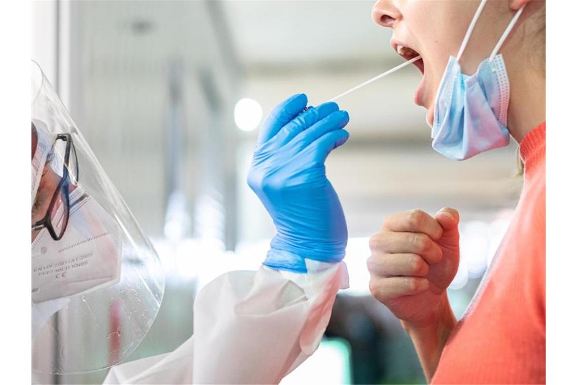 1540 Menschen im Südwesten neu mit dem Coronavirus infiziert Ein medizinischer Mitarbeiter entnimmt einer Frau einen Abstrich für einen Corona-Test. Foto: Moritz Frankenberg/dpa/Symbolbild