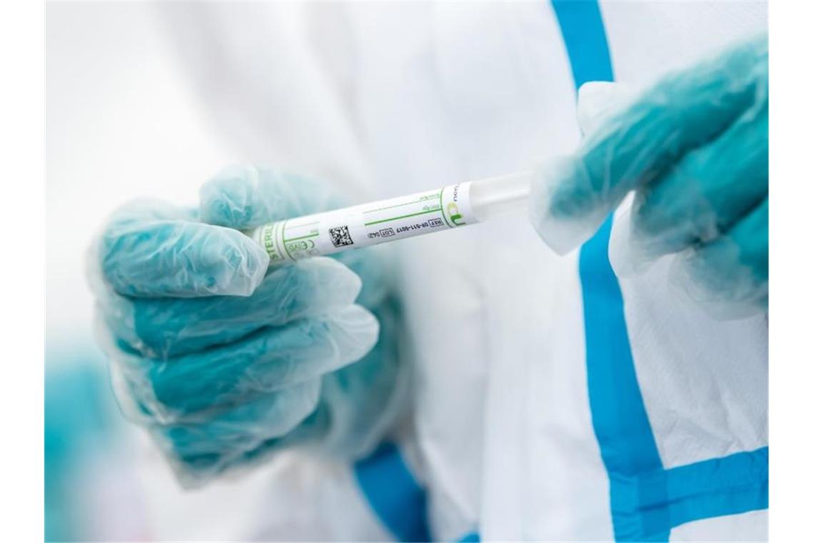 Corona-Inzidenz im Südwesten weiter rückläufig Ein medizinischer Mitarbeiter hält ein Teströhrchen mit einem Abstrich für einen Corona-Test in der Hand. Foto: Sven Hoppe/dpa/Symbolbild