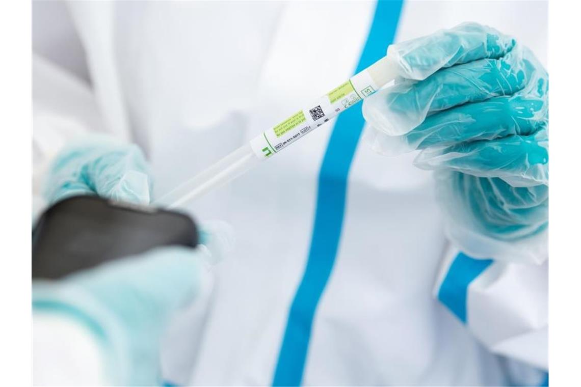 Ein medizinischer Mitarbeiter hält in einem Testzentrum ein Teströhrchen in der Hand. Foto: Sven Hoppe/dpa/Symbolbild