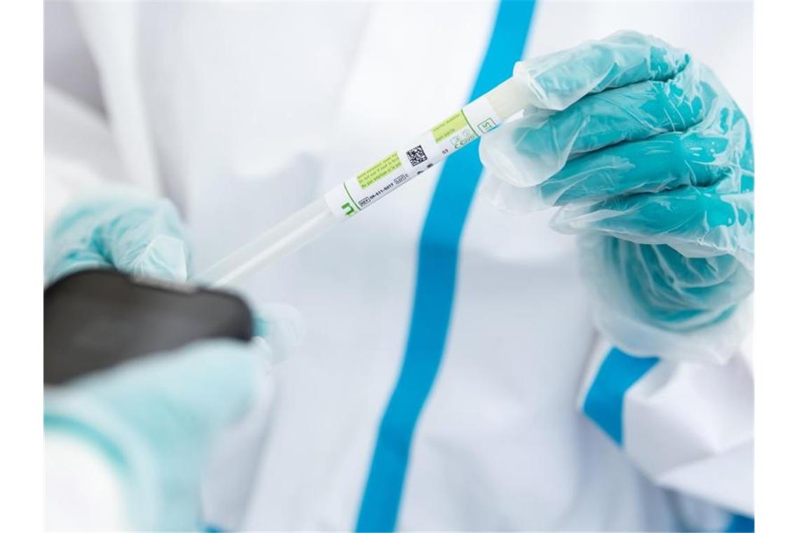 Ein medizinischer Mitarbeiter hält in einem Testzentrum ein Teströhrchen in der Hand. Foto: Sven Hoppe/dpa/Symbolbild