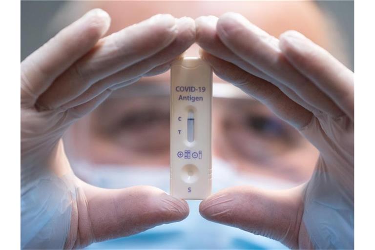 Ein medizinischer Mitarbeiter mit einem negativen Corona-Schnelltest. Foto: Sebastian Kahnert/dpa