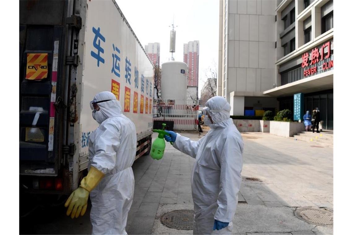 Ein medizinischer Mitarbeiter wird von einem Kollegen desinfiziert. Foto: Hao Yuan/XinHua/dpa