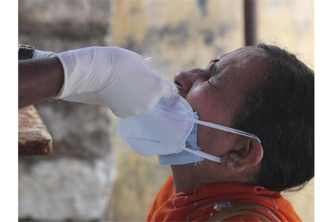 Ein medizinischer Mitarbeiterin der indischen Stadt Hyderabad entnimmt einer Frau einen Nasenabstrich für einen Corona-Test. Foto: Mahesh Kumar A/AP/dpa