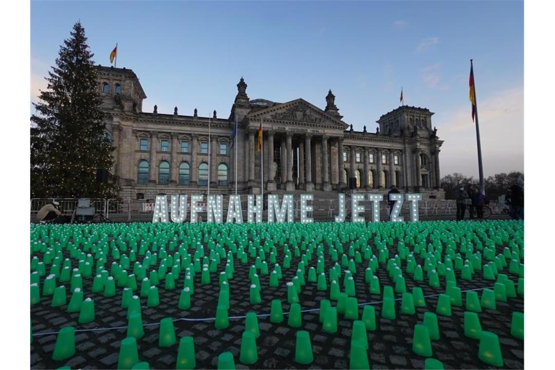 Ein Meer aus grünen Lichtern und der Schriftzug „Aufnahme Jetzt“ vor dem Reichstag in Berlin. Foto: Jörg Carstensen/dpa
