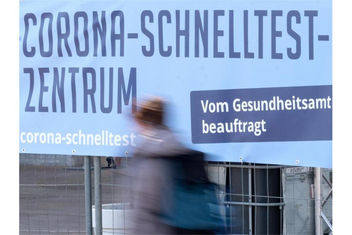 Ein Mensch geht an einem Hinweisschild für ein Schnelltest-Zentrum vorbei. Foto: Bernd Weißbrod/dpa/Symbolbild